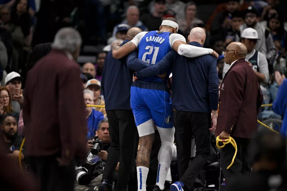 Dallas Mavericks center Daniel Gafford being helped off floor