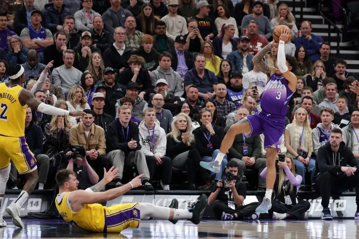Utah Jazz guard Keyonte George (3) knocks Los Angeles Lakers guard Luka Doncic (77) down and shoots during the second quarter at Delta Center.