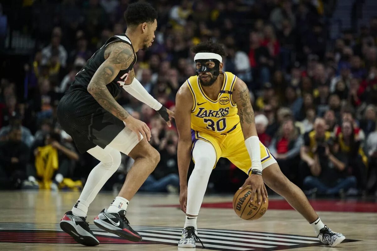 Feb 20, 2025; Portland, Oregon, USA; Los Angeles Lakers guard Jordan Goodwin (30) dribbles the ball during the second half against Portland Trail Blazers guard Anfernee Simons (1) at Moda Center. Mandatory Credit: Troy Wayrynen-Imagn Images