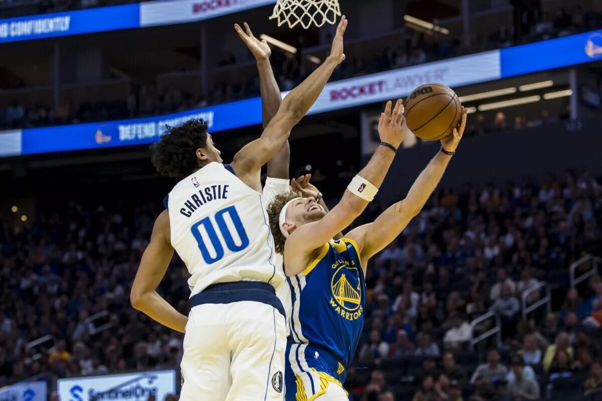 Feb 23, 2025; San Francisco, California, USA; Dallas Mavericks guard Max Christie (00) blocks a shot by Golden State Warriors guard Brandin Podziemski (2) during the fourth quarter at Chase Center. Mandatory Credit: John Hefti-Imagn Images
