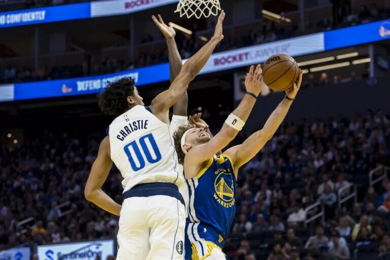Feb 23, 2025; San Francisco, California, USA; Dallas Mavericks guard Max Christie (00) blocks a shot by Golden State Warriors guard Brandin Podziemski (2) during the fourth quarter at Chase Center. Mandatory Credit: John Hefti-Imagn Images