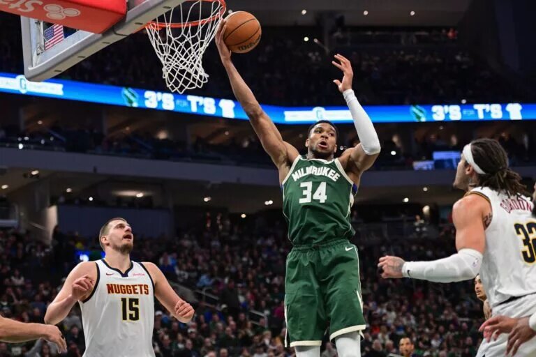 Feb 27, 2025; Milwaukee, Wisconsin, USA; Milwaukee Bucks forward Giannis Antetokounmpo (34) grabs a rebound against Denver Nuggets center Nikola Jokic (15) in the third quarter at Fiserv Forum. Mandatory Credit: Benny Sieu-Imagn Images