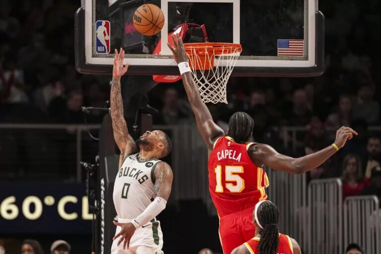Milwaukee Bucks guard Damian Lillard (0) lays in a basket behind Atlanta Hawks center Clint Capela (15)