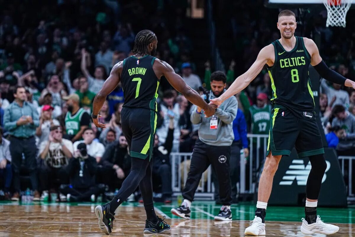 Boston Celtics guard Jaylen Brown (7) reacts with center Kristaps Porzingis