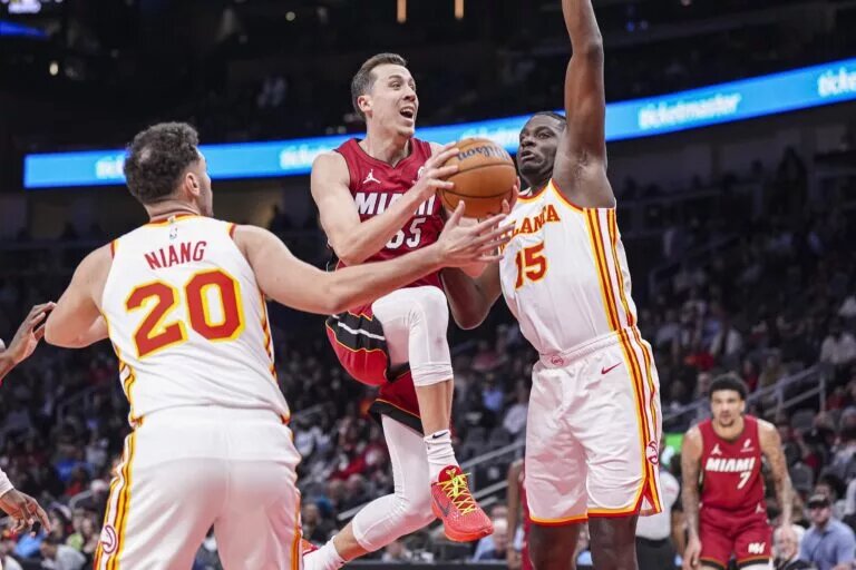Atlanta Hawks teammates Clint Capela and Georges Niang attempt to stop Miami Heat forward Duncan Robinson