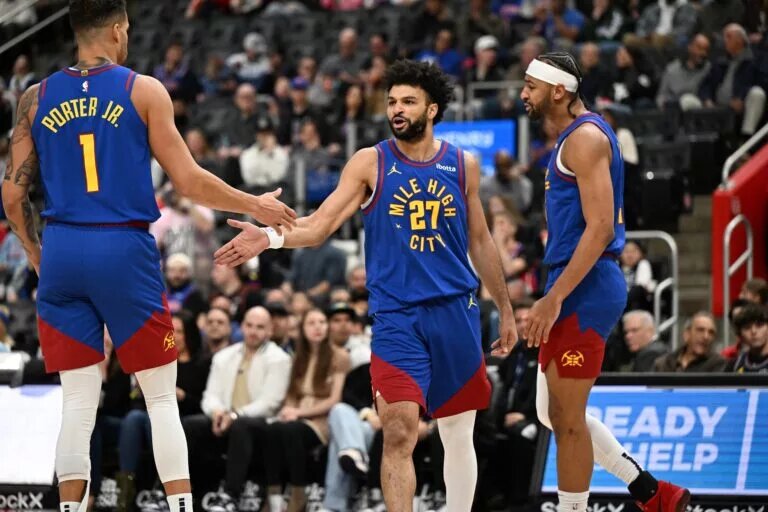 Feb 28, 2025; Detroit, Michigan, USA; Denver Nuggets guard Jamal Murray (27) celebrates with forwards Michael Porter Jr. (1) and Zeke Nnaji (22) after scoring and drawing a foul against the Detroit Pistons in the first quarter at Little Caesars Arena. Mandatory Credit: Lon Horwedel-Imagn Images