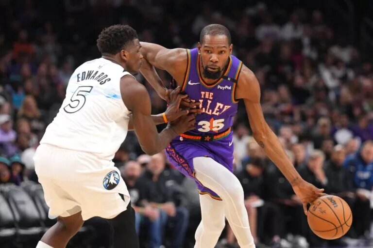 Phoenix Suns forward Kevin Durant (35) dribbles against Minnesota Timberwolves guard Anthony Edwards (5) during the second half at Footprint Center.