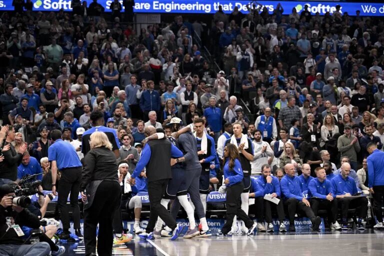 Dallas Mavericks guard Kyrie Irving (11) is helped off the court by forward Anthony Davis (3) during the second quarter against the Sacramento Kings at the American Airlines Center.