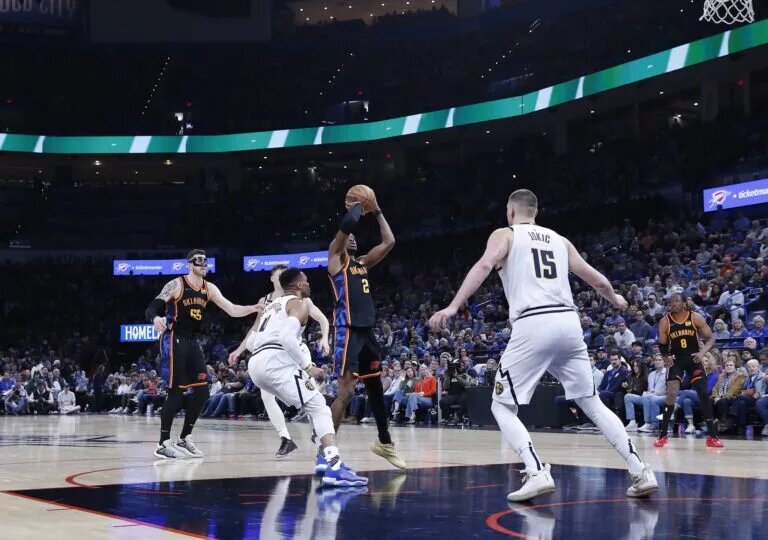 Oklahoma City Thunder guard Shai Gilgeous-Alexander (SGA) shoots against Nikola Jokic and the Denver Nuggets defense