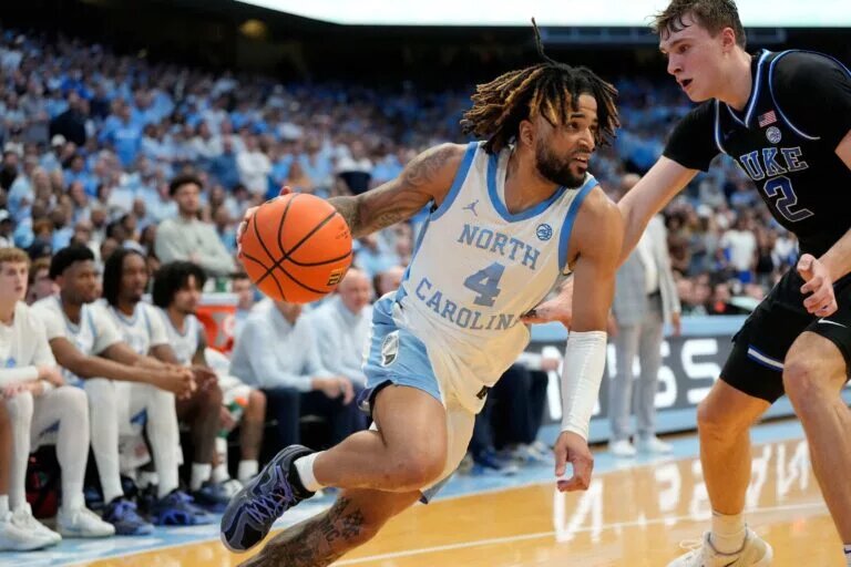 Mar 8, 2025; Chapel Hill, North Carolina, USA; North Carolina Tar Heels guard RJ Davis (4) with the ball as Duke Blue Devils forward Cooper Flagg (2) defends in the second half at Dean E. Smith Center. Mandatory Credit: Bob Donnan-Imagn Images