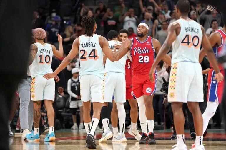 Mar 21, 2025; San Antonio, Texas, USA; Philadelphia 76ers forward Guerschon Yabusele (28) congratulates San Antonio Spurs guard Devin Vassell (24) on a win at Frost Bank Center.