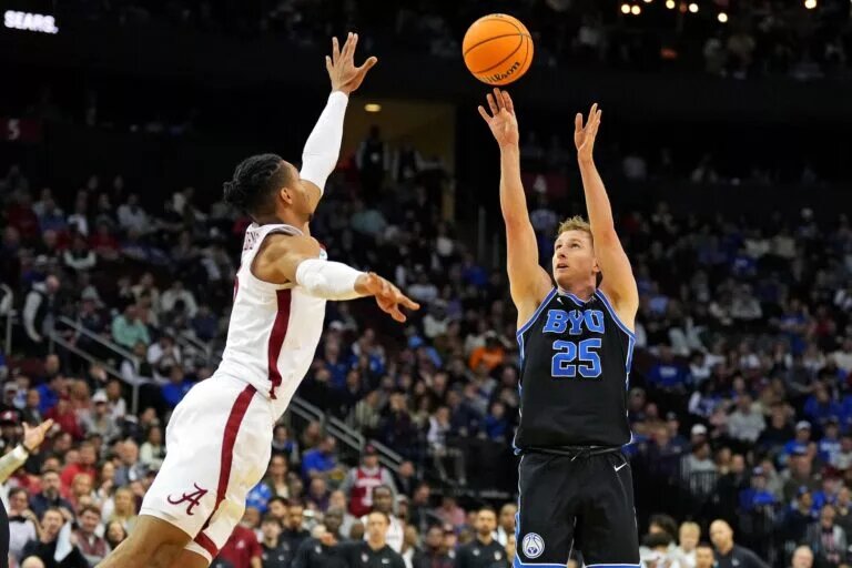 Mar 27, 2025; Newark, NJ, USA; Brigham Young Cougars guard Dawson Baker (25) shoots the ball against Alabama Crimson Tide forward Jarin Stevenson (15) during the second half during an East Regional semifinal of the 2025 NCAA tournament at Prudential Center. Mandatory Credit: Robert Deutsch-Imagn Images