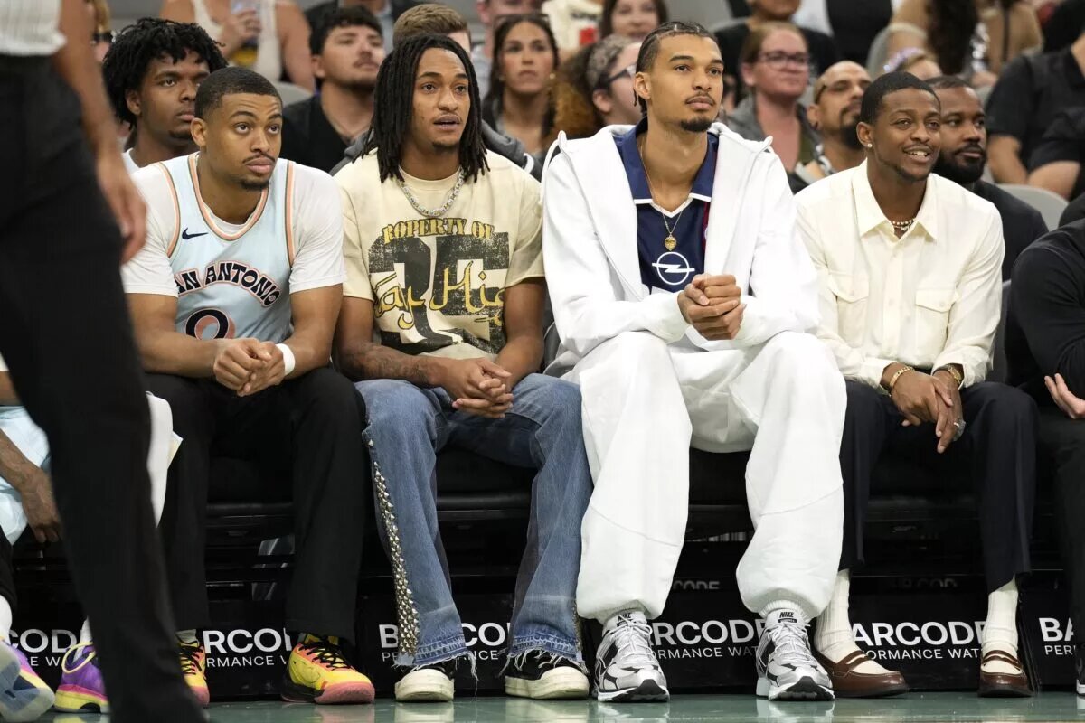 San Antonio Spurs (from left to right) forward Keldon Johnson (0), guard Devin Vassell (24), center Victor Wembanyama (1) and guard De'Aron Fox (4) watch the first half of a game