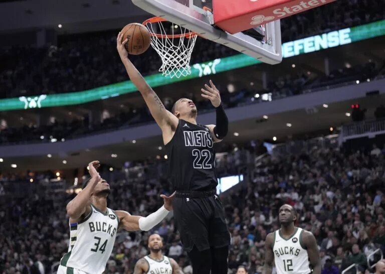 Jan 2, 2025; Milwaukee, Wisconsin, USA; Brooklyn Nets forward Jalen Wilson (22) puts up a shot against Milwaukee Bucks forward Giannis Antetokounmpo (34) and Milwaukee Bucks forward Taurean Prince (12) in the second half at Fiserv Forum. Mandatory Credit: Michael McLoone-Imagn Images