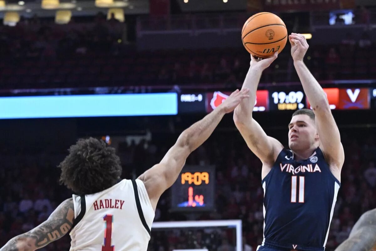 Jan 18, 2025; Louisville, Kentucky, USA; Virginia Cavaliers guard Isaac McKneely (11) shoots against Louisville Cardinals guard J'Vonne Hadley (1) during the first half at KFC Yum! Center. Mandatory Credit: Jamie Rhodes-Imagn Images