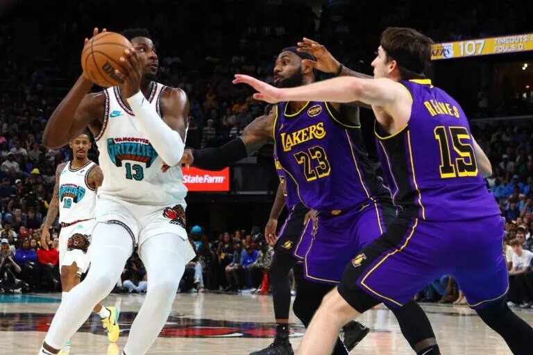 Mar 29, 2025; Memphis, Tennessee, USA; Memphis Grizzlies forward Jaren Jackson Jr. (13) spins to the basket as Los Angeles Lakers forward LeBron James (23) and Los Angeles Lakers guard Austin Reaves (15) defend during the fourth quarter at FedExForum. Mandatory Credit: Petre Thomas-Imagn Images