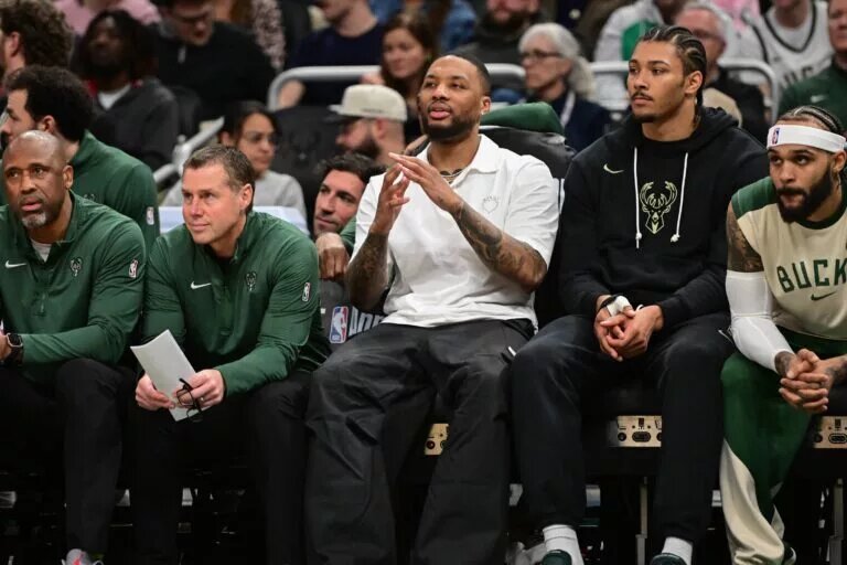 Apr 1, 2025; Milwaukee, Wisconsin, USA; Milwaukee Bucks guard Damian Lillard (center) looks on from the bench while sidelined with an injury in the third quarter against the Phoenix Suns at Fiserv Forum. Mandatory Credit: Benny Sieu-Imagn Images