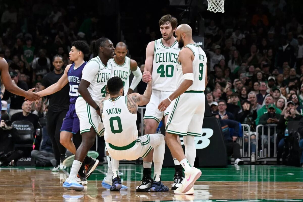 Boston Celtics guard Jrue Holiday (4) and .center Luke Kornet (40) help forward Jayson Tatum
