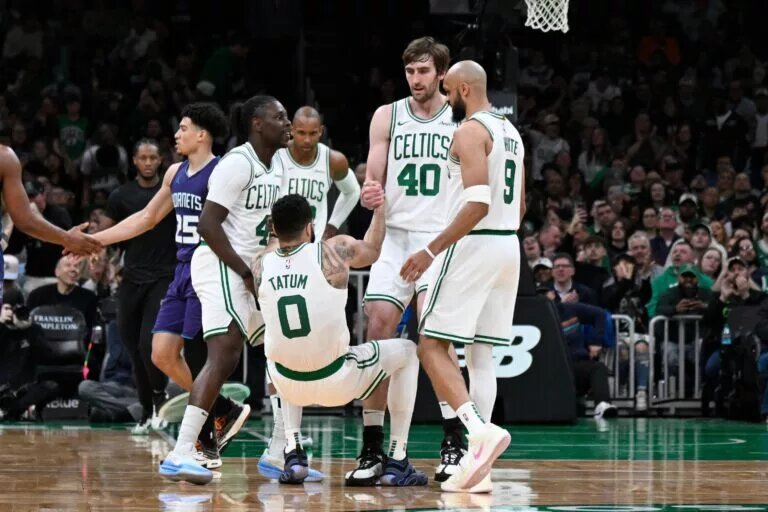 Boston Celtics guard Jrue Holiday (4) and .center Luke Kornet (40) help forward Jayson Tatum