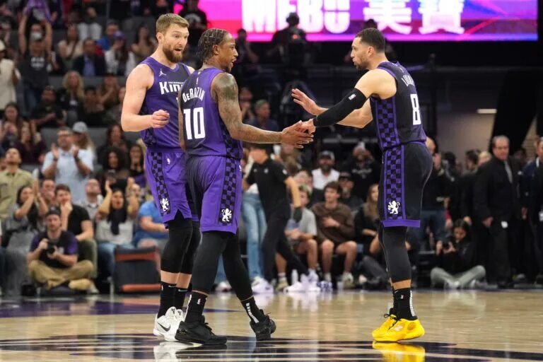 Sacramento Kings forward DeMar DeRozan (10) talks with forward Domantas Sabonis (left) and guard Zach LaVine