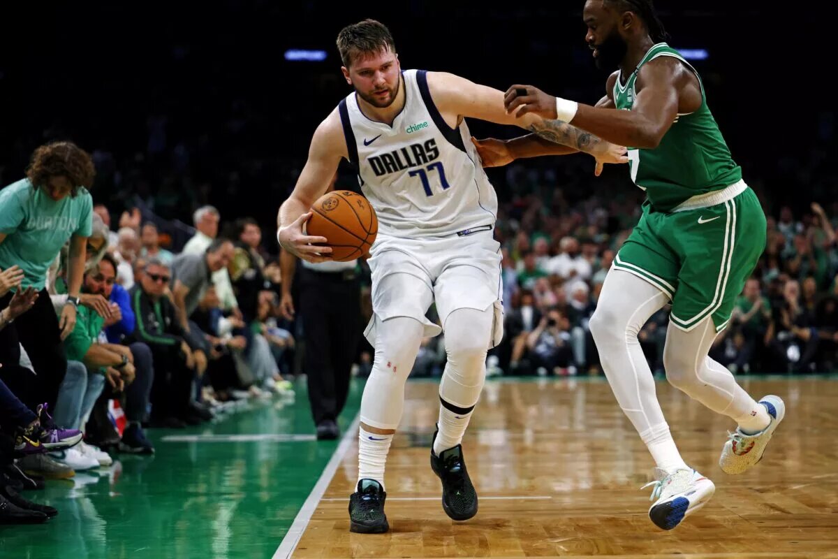 Dallas Mavericks guard Luka Doncic (77) handles the ball against Boston Celtics guard Jaylen Brown (7)