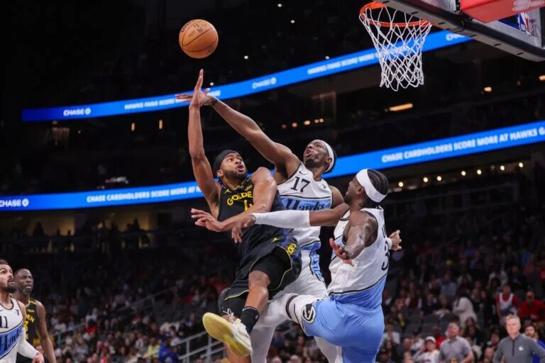 Golden State Warriors guard Moses Moody (4) shoots past Atlanta Hawks forward Onyeka Okongwu (17) and guard Caris LeVert (3)