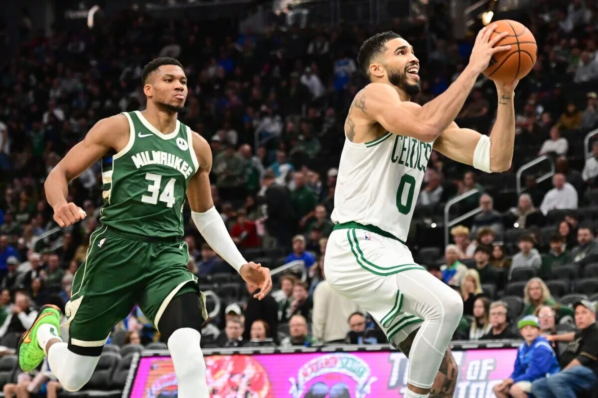 Nov 10, 2024; Milwaukee, Wisconsin, USA; Boston Celtics forward Jayson Tatum (0) takes a shot against Milwaukee Bucks forward Giannis Antetokounmpo (34) in the third quarter at Fiserv Forum. Mandatory Credit: Benny Sieu-Imagn Images