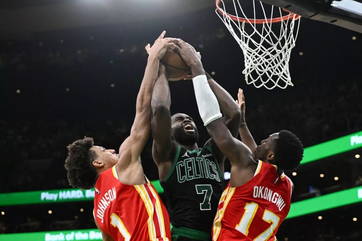 Jan 18, 2025; Boston, Massachusetts, USA; Atlanta Hawks forward Jalen Johnson (1) and forward Onyeka Okongwu (17) defend Boston Celtics guard Jaylen Brown (7) during the fourth quarter at the TD Garden. Mandatory Credit: Brian Fluharty-Imagn Images