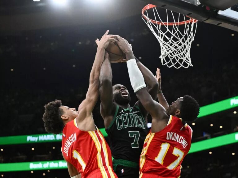Jan 18, 2025; Boston, Massachusetts, USA; Atlanta Hawks forward Jalen Johnson (1) and forward Onyeka Okongwu (17) defend Boston Celtics guard Jaylen Brown (7) during the fourth quarter at the TD Garden. Mandatory Credit: Brian Fluharty-Imagn Images