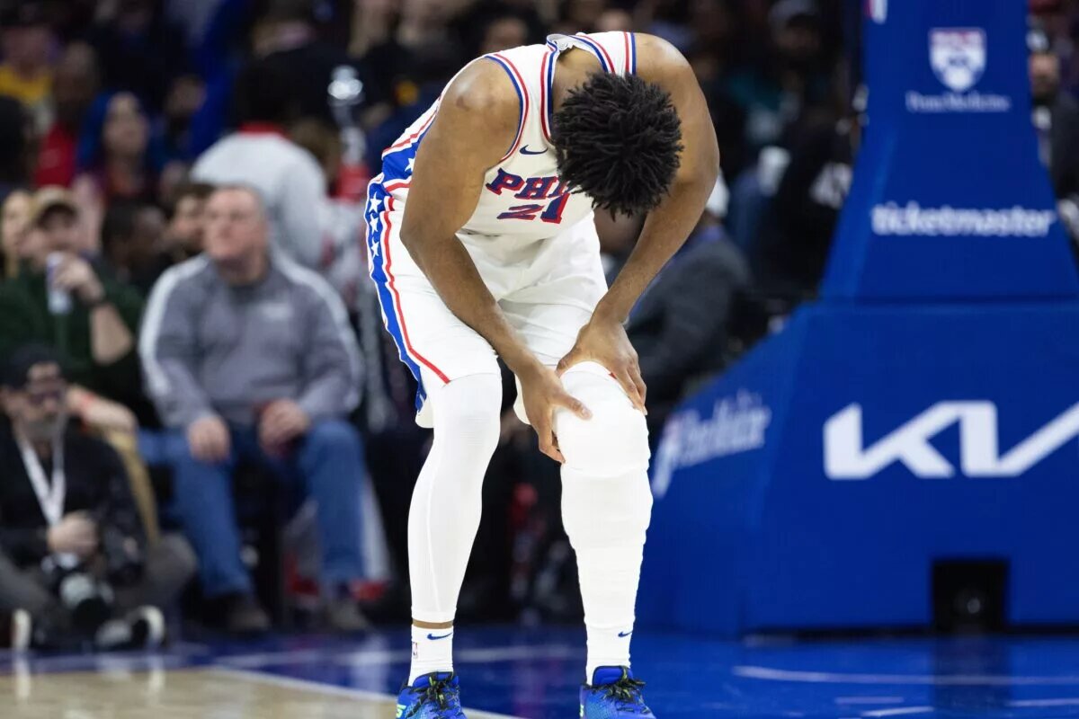 Philadelphia 76ers center Joel Embiid (21) holds his leg after a play against the Brooklyn Nets during the second quarter at Wells Fargo Center.