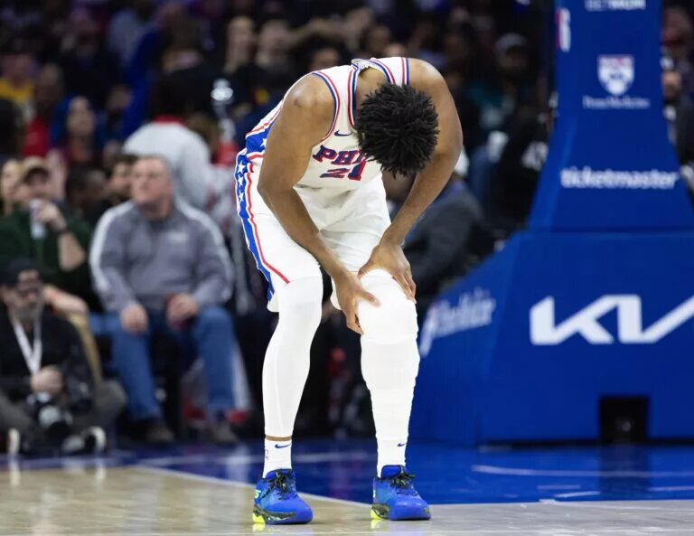 Philadelphia 76ers center Joel Embiid (21) holds his leg after a play against the Brooklyn Nets during the second quarter at Wells Fargo Center.