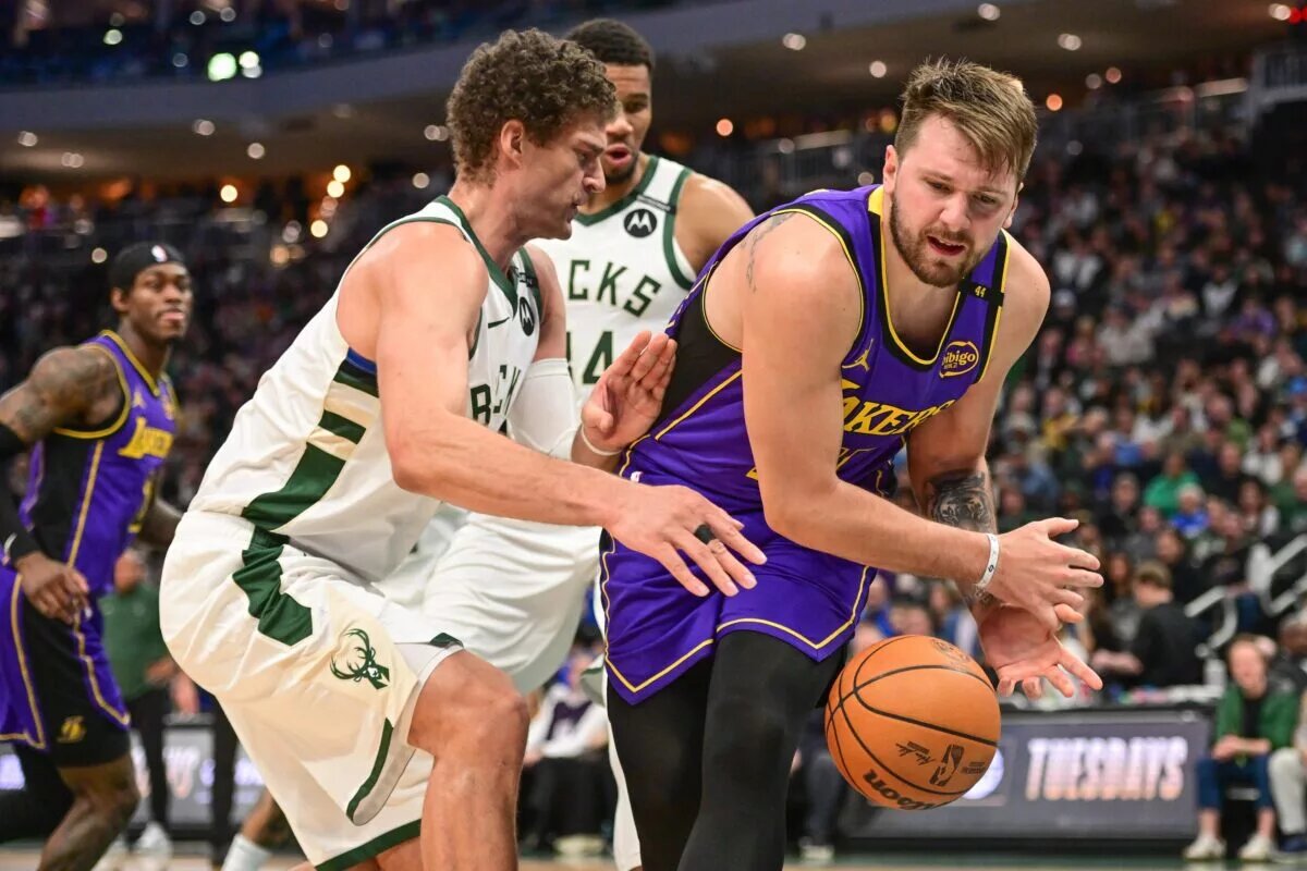 Mar 13, 2025; Milwaukee, Wisconsin, USA; Milwaukee Bucks center Brook Lopez (11) defends Los Angeles Lakers guard Luka Doncic (77) in the third quarter at Fiserv Forum. Mandatory Credit: Benny Sieu-Imagn Images