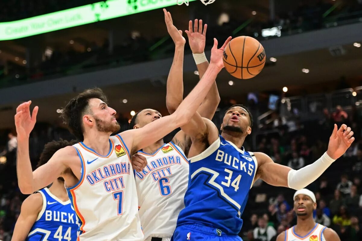 Mar 16, 2025; Milwaukee, Wisconsin, USA; Milwaukee Bucks forward Giannis Antetokounmpo (34) reaches for the ball against Oklahoma City Thunder center Chet Holmgren (7) and forward Jaylin Williams (6) in the fourth quarter at Fiserv Forum. Mandatory Credit: Benny Sieu-Imagn Images