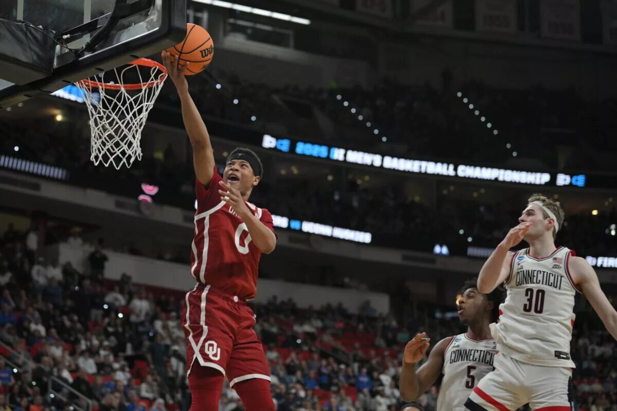 Mar 21, 2025; Raleigh, NC, USA; Oklahoma Sooners guard Jeremiah Fears (0) puts up shot against Connecticut Huskies forward Liam McNeeley (30) during the second half at Lenovo Center. Mandatory Credit: Zachary Taft-Imagn Images