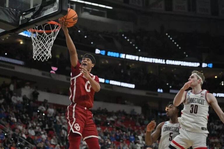 Mar 21, 2025; Raleigh, NC, USA; Oklahoma Sooners guard Jeremiah Fears (0) puts up shot against Connecticut Huskies forward Liam McNeeley (30) during the second half at Lenovo Center. Mandatory Credit: Zachary Taft-Imagn Images