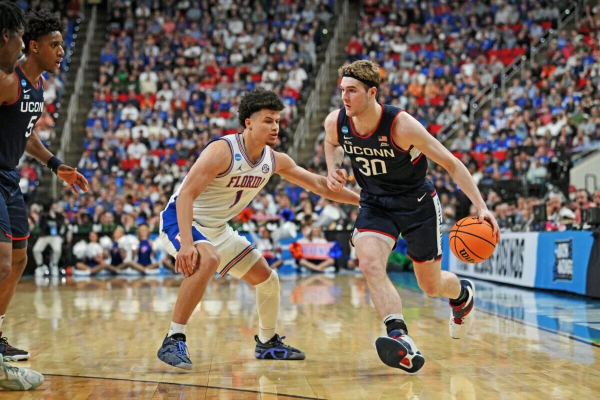 Mar 23, 2025; Raleigh, NC, USA; Connecticut Huskies forward Liam McNeeley (30) drives to the basket during the second half against Florida Gators guard Walter Clayton Jr. (1) in the second round of the NCAA Tournament at Lenovo Center. Mandatory Credit: Zachary Taft-Imagn Images