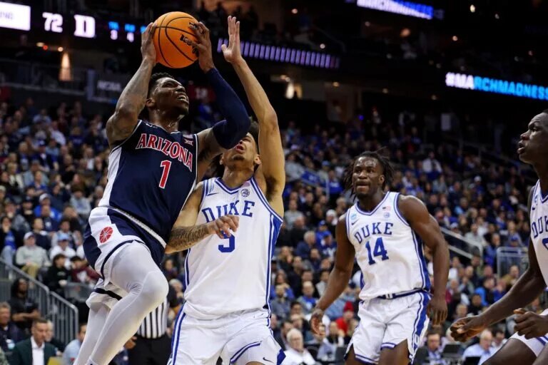 Mar 27, 2025; Newark, NJ, USA; Arizona Wildcats guard Caleb Love (1) shoots the ball against Duke Blue Devils guard Tyrese Proctor (5) during the second half during an East Regional semifinal of the 2025 NCAA tournament at Prudential Center. Mandatory Credit: Vincent Carchietta-Imagn Images