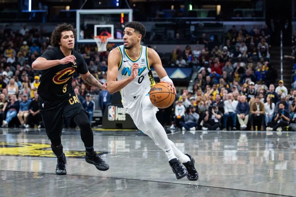Apr 10, 2025; Indianapolis, Indiana, USA; Indiana Pacers guard Tyrese Haliburton (0) dribbles the ball while Cleveland Cavaliers guard Craig Porter Jr. (9) defends in the second half at Gainbridge Fieldhouse. Mandatory Credit: Trevor Ruszkowski-Imagn Images