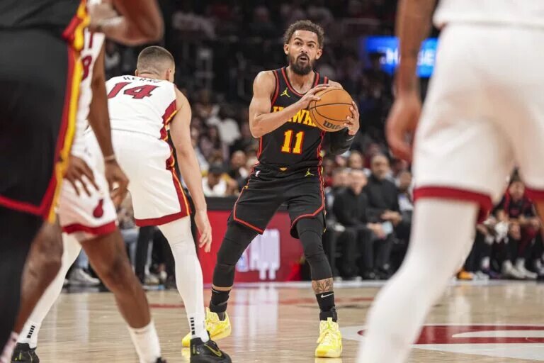 Atlanta Hawks guard Trae Young (11) controls the ball against Miami Heat guard Tyler Herro (14) during the first half at State Farm Arena.