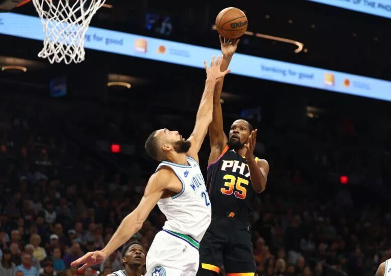Phoenix Suns forward Kevin Durant attempts to shoot over Minnesota Timberwolves center Rudy Gobert