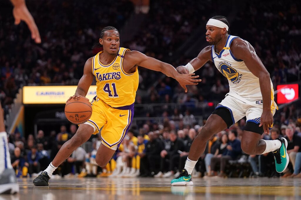 Oct 18, 2024; San Francisco, California, USA; Los Angeles Lakers guard Quincy Olivari (41) dribbles past Golden State Warriors guard Buddy Hield (7) in the second quarter at the Chase Center. Mandatory Credit: Cary Edmondson-Imagn Images