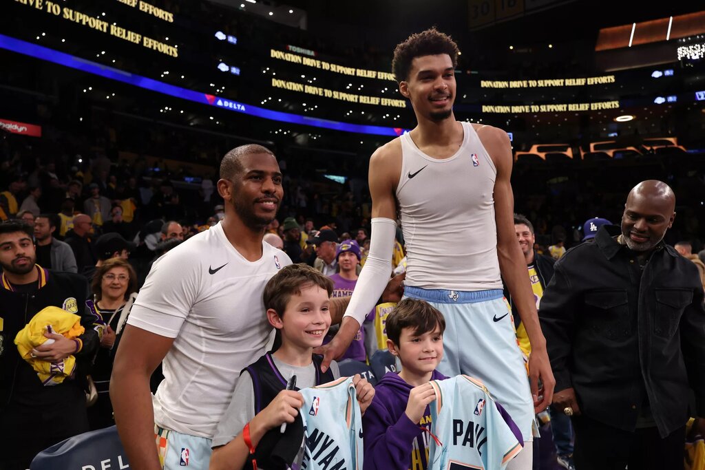 Jan 13, 2025; Los Angeles, California, USA; San Antonio Spurs guard Chris Paul (3, left) and center Victor Wembanyama (1,right) pose for a photo with Los Angeles Lakers head coach JJ Redick's sons after defeating the Lakers 126-102 at Crypto.com Arena. Mandatory Credit: Kiyoshi Mio-Imagn Images