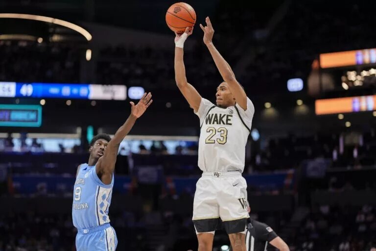 Mar 13, 2025; Charlotte, NC, USA; Wake Forest Demon Deacons guard Hunter Sallis (23) shoots defended by North Carolina Tar Heels guard Drake Powell (9) during the second half at Spectrum Center. Mandatory Credit: Jim Dedmon-Imagn Images