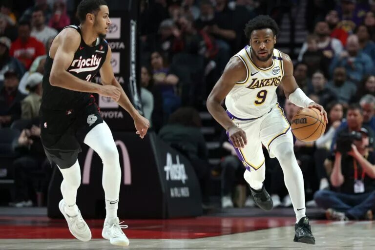 Apr 13, 2025; Portland, Oregon, USA; Los Angeles Lakers guard Bronny James (9) brings the ball up the court past Portland Trail Blazers forward Kris Murray (24) in the second half at Moda Center. Mandatory Credit: Jaime Valdez-Imagn Images