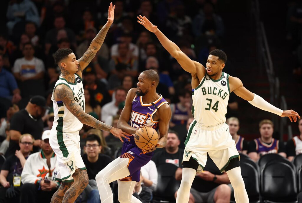 Mar 24, 2025; Phoenix, Arizona, USA; Milwaukee Bucks forward Kyle Kuzma (18) and forward Giannis Antetokounmpo (34) defend against Phoenix Suns forward Kevin Durant (35) at Footprint Center. Mandatory Credit: Mark J. Rebilas-Imagn Images