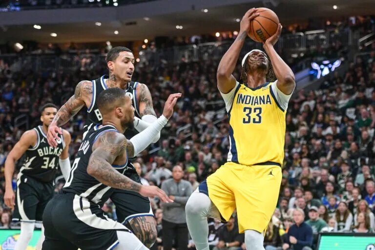 Indiana Pacers center Myles Turner (33) takes a shot against Milwaukee Bucks guard Damian Lillard (0) and forward Kyle Kuzma (18)