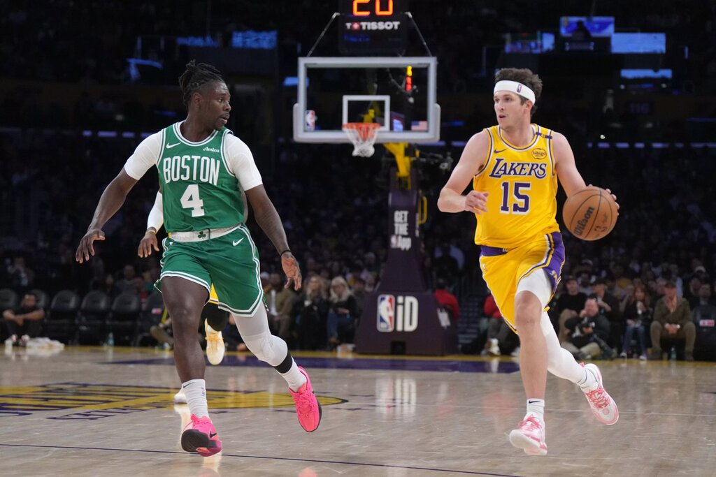 Jan 23, 2025; Los Angeles, California, USA; Los Angeles Lakers guard Austin Reaves (15) dribbles the ball against Boston Celtics guard Jrue Holiday (4) in the second half at the Crypto.com Arena. Mandatory Credit: Kirby Lee-Imagn Images