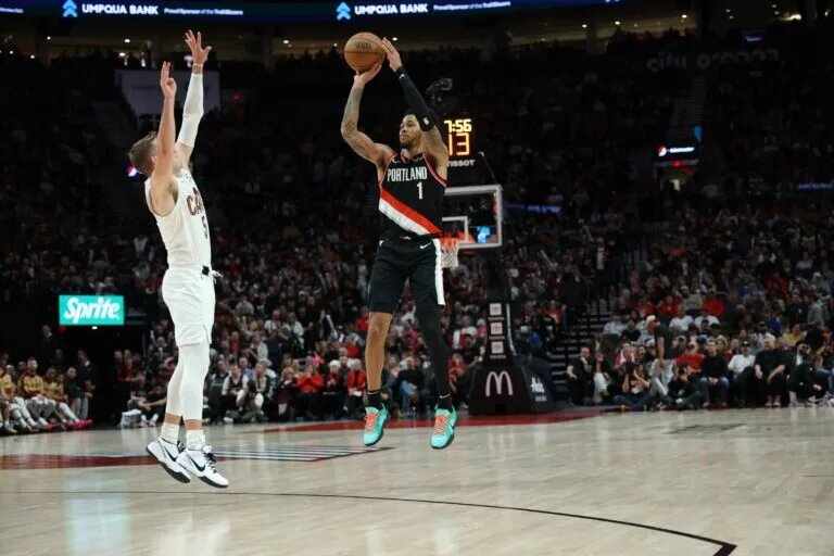 Portland Trail Blazers guard Anfernee Simons (1) shoots the ball over Cleveland Cavaliers guard Sam Merrill (5) in the second half at Moda Center.