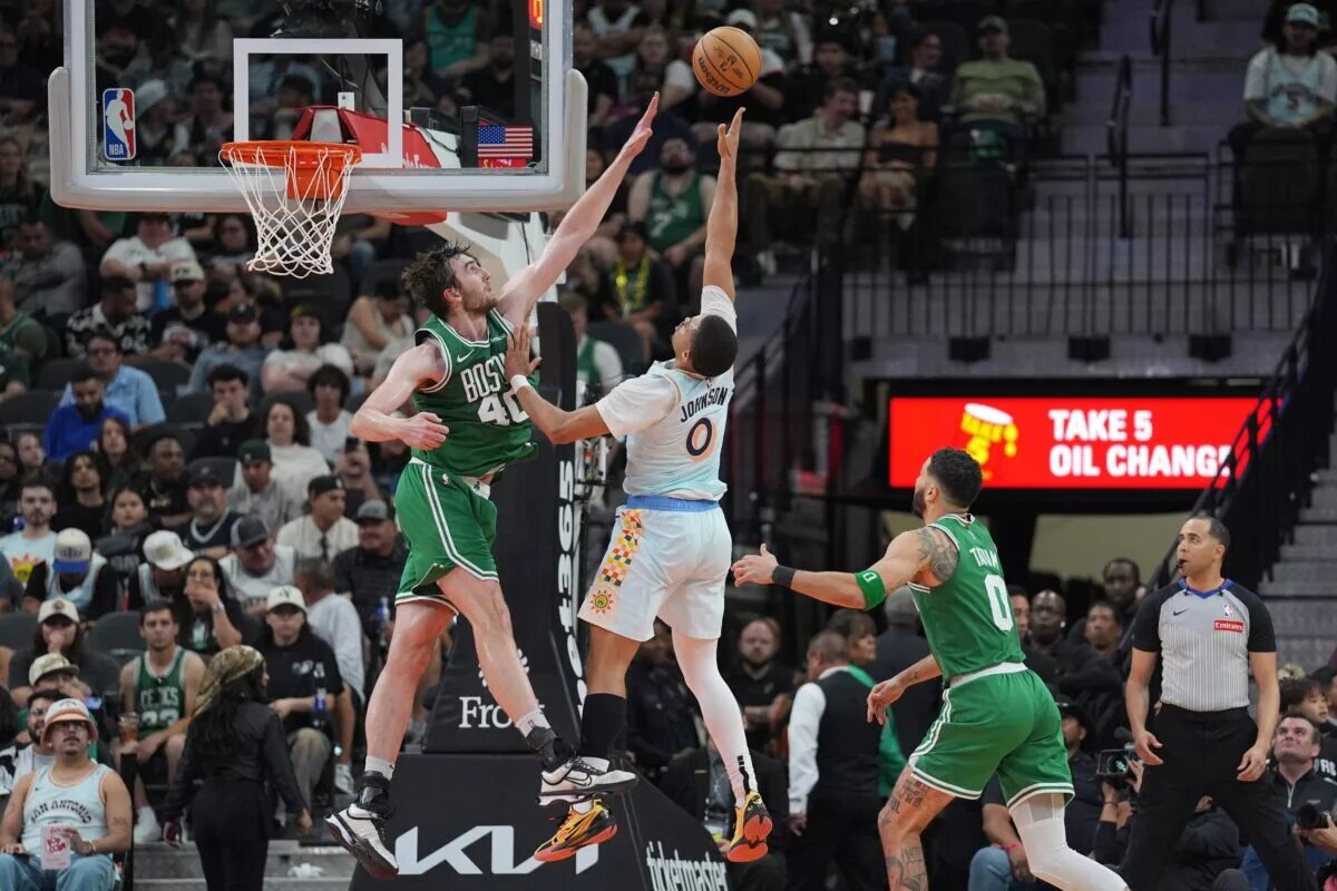 Mar 29, 2025; San Antonio, Texas, USA; San Antonio Spurs forward Keldon Johnson (0) shoots against Boston Celtics center Luke Kornet (40) in the second half at Frost Bank Center. Mandatory Credit: Daniel Dunn-Imagn Images