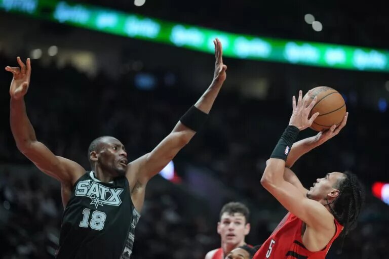 Apr 6, 2025; Portland, Oregon, USA; Portland Trail Blazers guard Dalano Banton (5) shoots over San Antonio Spurs center Bismack Biyombo (18) during the second half at Moda Center. Mandatory Credit: Soobum Im-Imagn Images